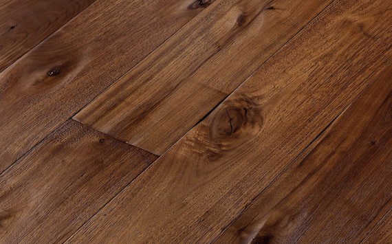Engineered wood planks floor in American Walnut: brushed, stained, hand carved, varnished.