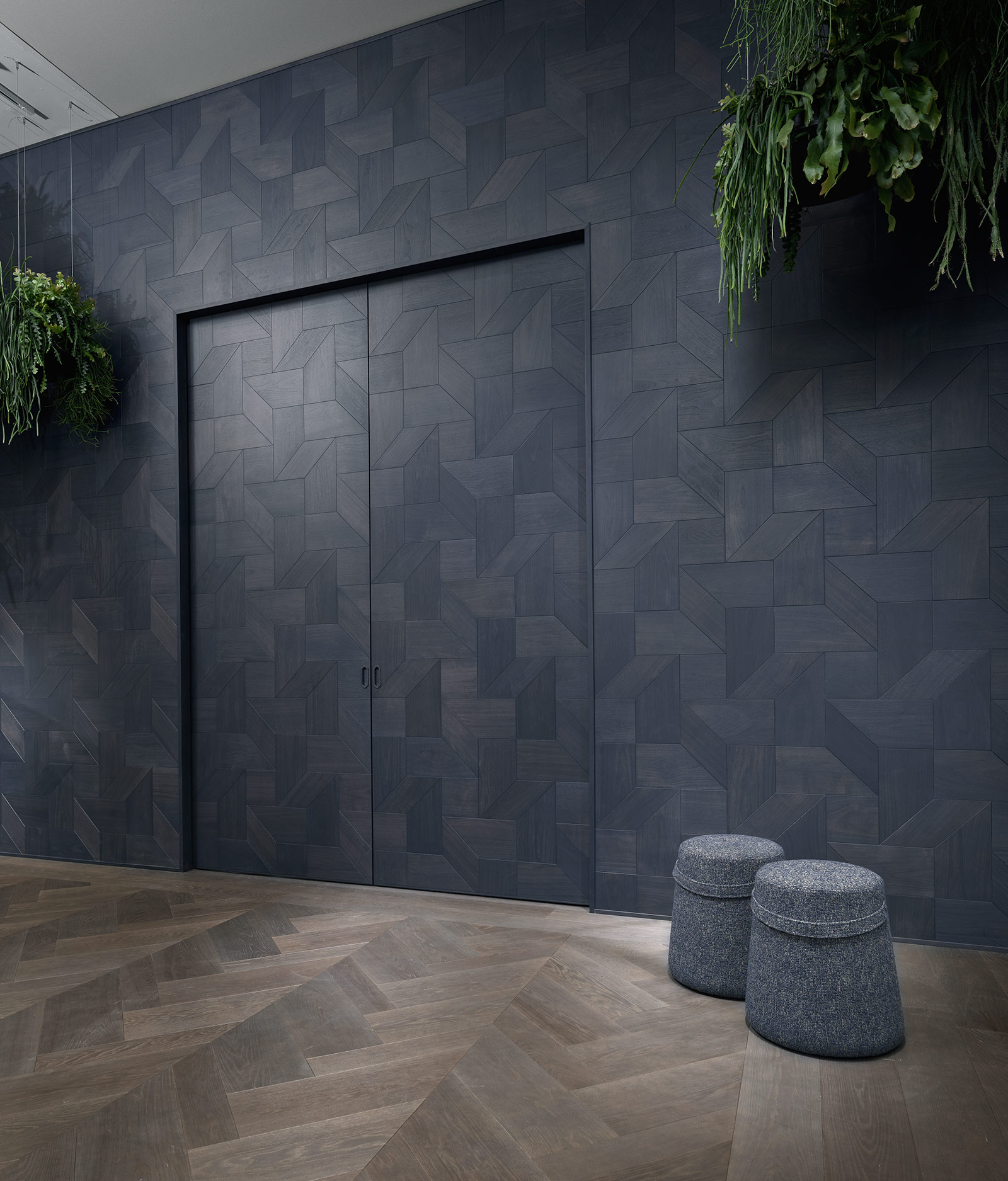Двустворчатая дверь, интегрированная в буазери Tricot от Foglie d’Oro в отделке Colorsense Ocean Blue, согласованная с геометрическим деревянным полом.