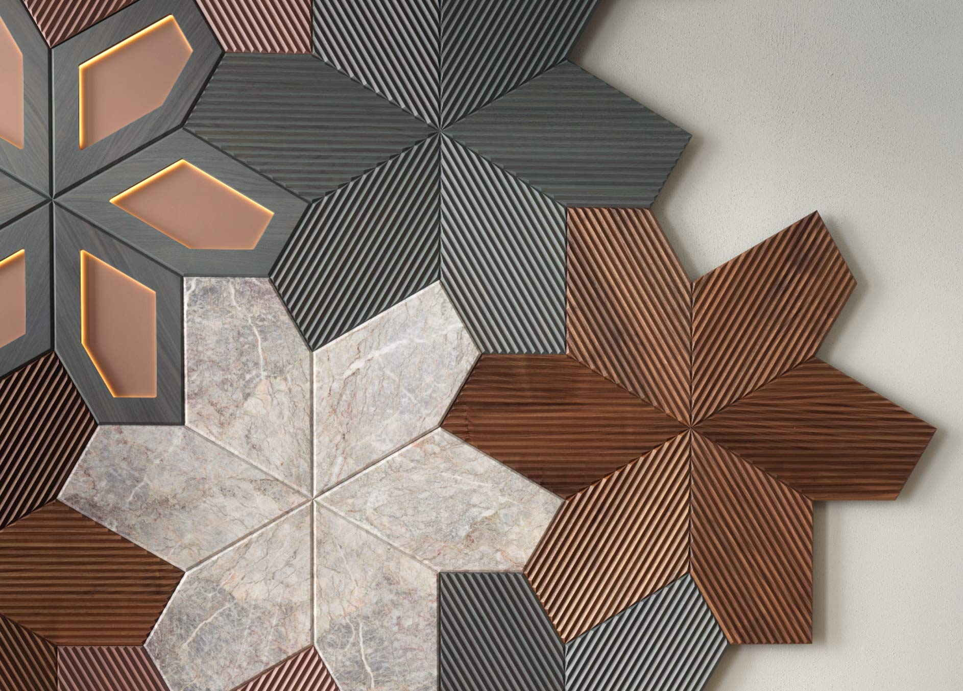 Détail du revêtement mural Azalea de Foglie d’Oro - avec modules floraux tridimensionnels en bois fraisé et en marbre clair plus inserts lumineux dans les tons cuivrés.