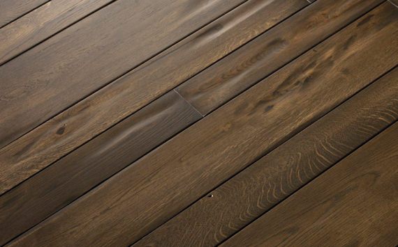 Engineered wood planks floor in Oak: brushed, stained, aged effect, handmade rounded bevels, hand carved, varnished.
